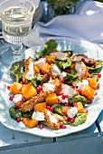 Chicken salad with pumpkin, goat's cheese, spinach and pomegranate dressing