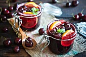 Jam with black cherries and lemon slices in flip-top jars
