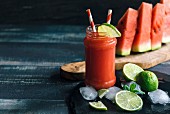 Watermelon juice in a glass with limes