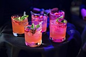 Tray of rasberry, mint, vodka cocktails being served at an event