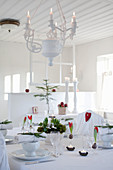 Weihnachtlich gedeckter Tisch im ländlichen Esszimmer in Weiß