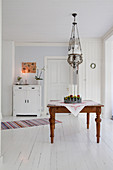 Traditional ceiling lamp above country-house table on white wooden floor