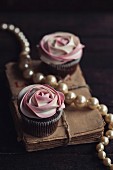 White rosese cupcakes served on wooden background
