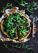 Vegetarische Pizza mit Rucola, Pesto und Oliven