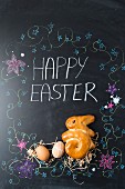 Easter eggs and a bunny (shaped yeast bread) on a chalkboard