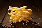 A stack of french fries on a wooden table