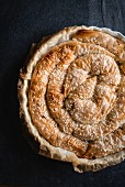 Whole homemade potetoes pie on dark background