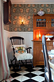 Black rocking chairs next to old dresser on chequered floor