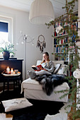 Woman seated on récamier reading in cosy living room