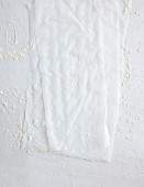 Baking paper on a white background, dusted with flour