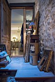 Gilt frames leaning against stone wall on wooden landing