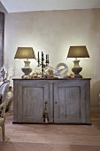 Two table lamps and peace dove ornament on vintage sideboard