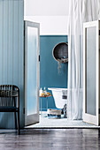 View through open saloon doors into the blue and white bathroom of a beach house