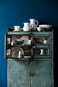 Porcelain collection in a blue vintage buffet cabinet