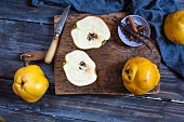 Quince, whole and sliced, on a wooden board