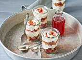 Rhubarb layered desserts with curd cream and rhubarb syrup on a tray