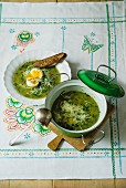 Neun-Kräuter-Suppe serviert mit wachsweichem Ei und Brot
