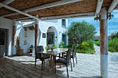Tisch und Stühle auf der Terrasse eines mediterranen Hauses