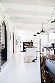 Open, white kitchen with vintage furnishings in a former church