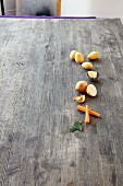 Potatoes, butter, onion, carrots, and bay leaves on a wooden background