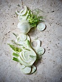 Fennel bulbs, whole and sliced, on a stone background