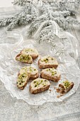 Christmas biscuits decorated with icing sugar and pistachios to look like open sandwiches