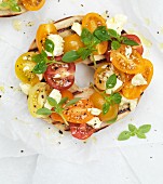 A grilled bagel with cherry tomatoes and feta cheese (top view, close up)