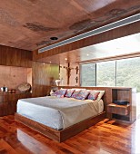 Modernes Schlafzimmer mit rot gefärbtem Beton und Holz