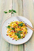 Yellow tomato salad with pomegranate seeds