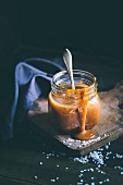 Salted caramel sauce in a glass with a spoon