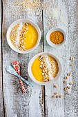 Gelbe Smoothie-Bowl mit Mango, Ananas, Banane, Kurkuma und Getreidepops