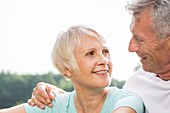 Senior couple smiling, man with arm around woman