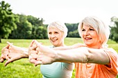 Two women exercising with arms outstretched