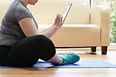 Woman sitting on floor using digital tablet