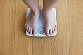 Woman standing on weighing scales