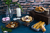 A Christmas table laid with various Christmas cakes and biscuits