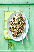 Baked potato salad with gherkins, red radishes and goat's cheese