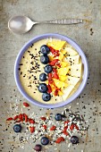 A tropical smoothie bowl with mango, pineapple, goji berries and coconut milk