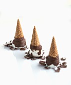 Chocolate-covered ice cream cones tipped upside down