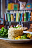 Risotto au bouillon with vegetables and side salad on a table