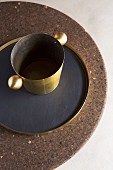 Brass wine cooler and tray on round cork table