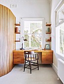 Old Windsor chair in front of a modern desk next to a round wall