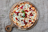 A cheese pizza with bresaola and basil
