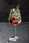 A cocktail with fresh berries and mint