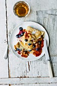 Flambéed blueberry crepes with milk chocolate and peanut sauce