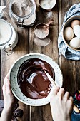 Geschmolzene Schokolade in Keramikschale verrühren