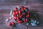 Fresh cherries in a ceramic bowl on a rustic wooden table