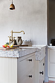 Stone worksurface and sink in country-house kitchen