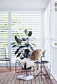 Filigree metal furniture on the terrace with slatted walls