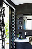 Modern bathroom in black with slate tiles and louvre windows